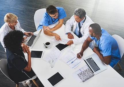 Healthcare professionals reviewing population health strategy materials Healthcare professionals reviewing population health strategy materials