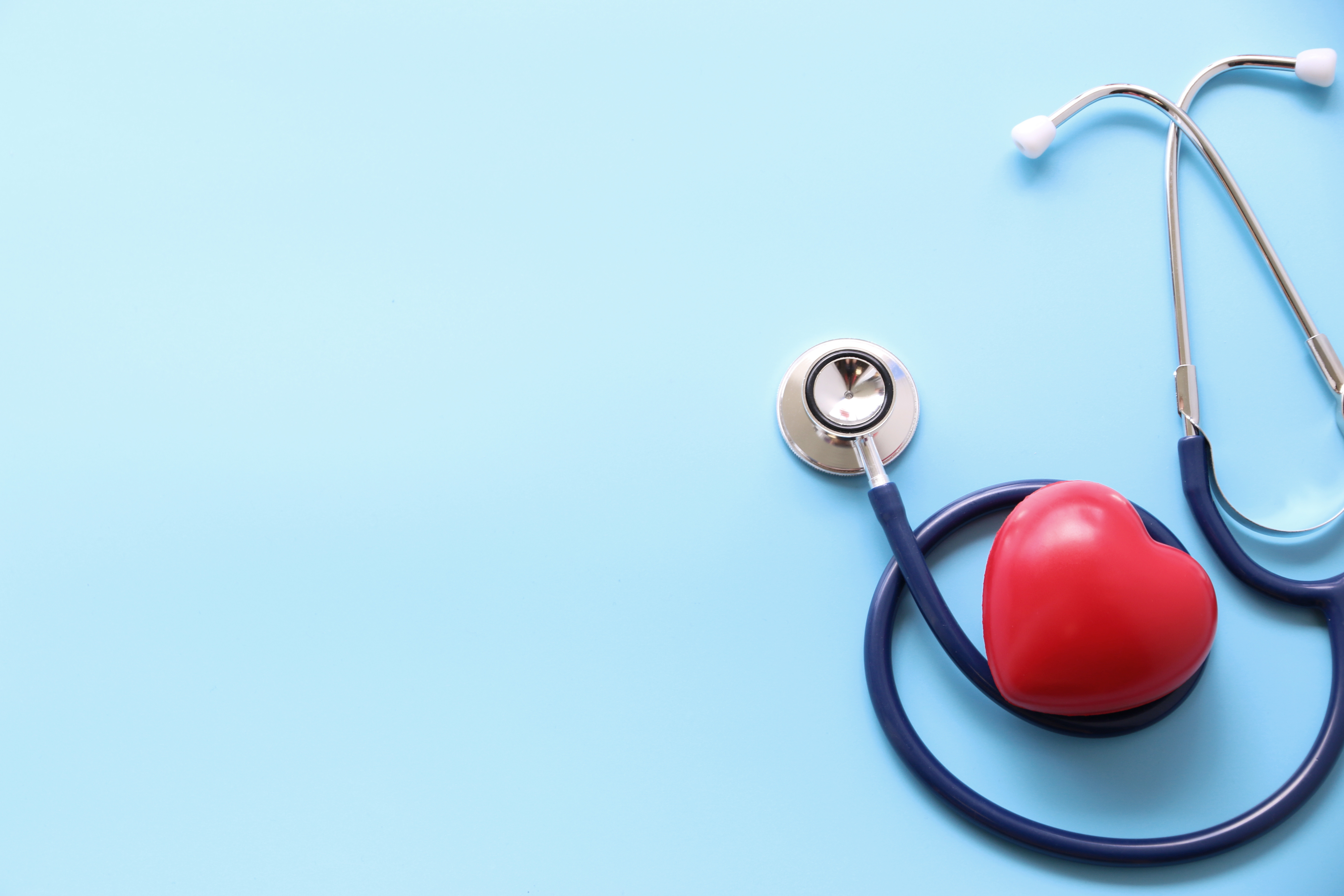 Heart wrapped in a stethoscope, symbolizing managing cholesterol.