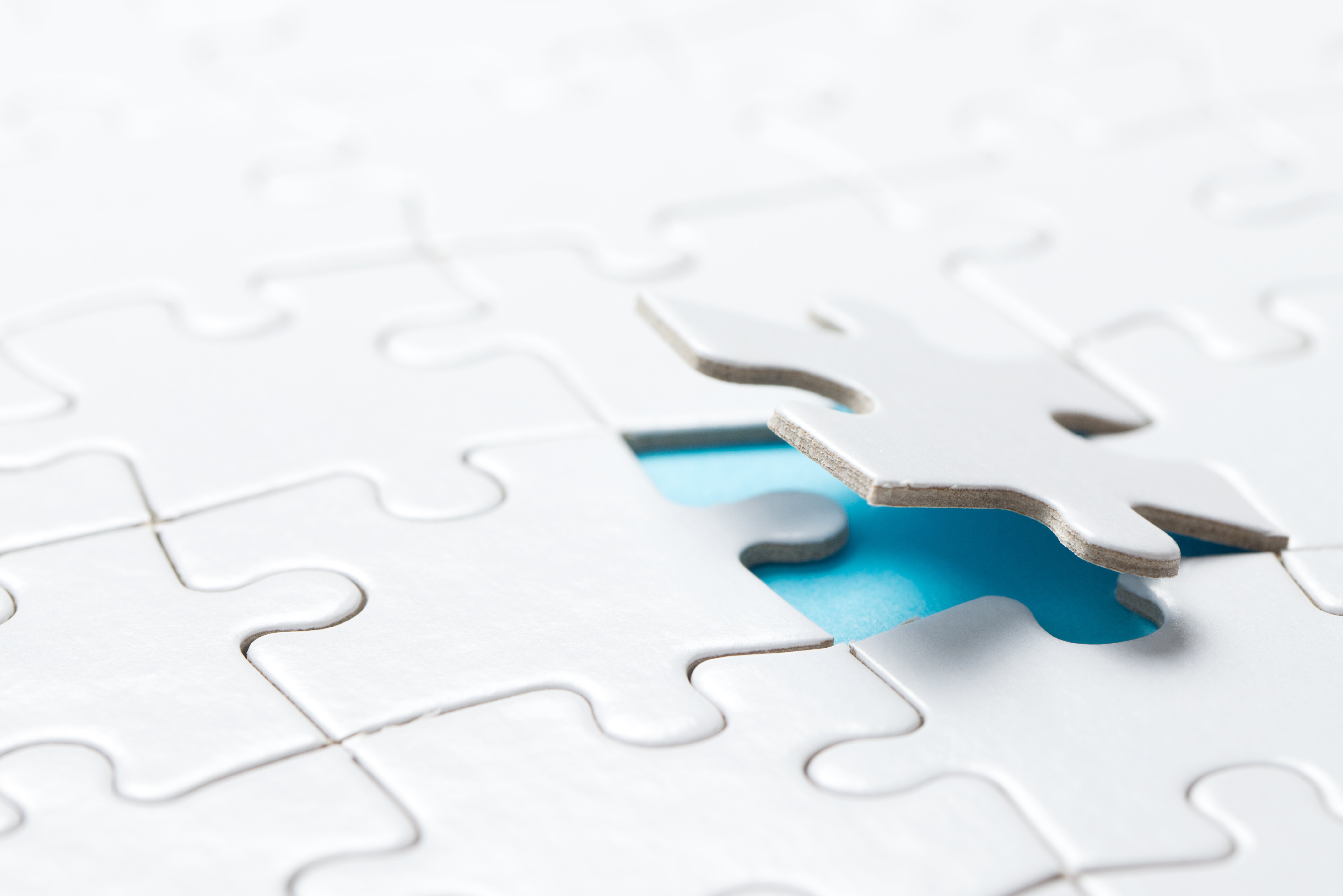Illustration of a puzzle piece being lifted from a completed puzzle, symbolizing the complexity and challenges of working with health plan claims data.
