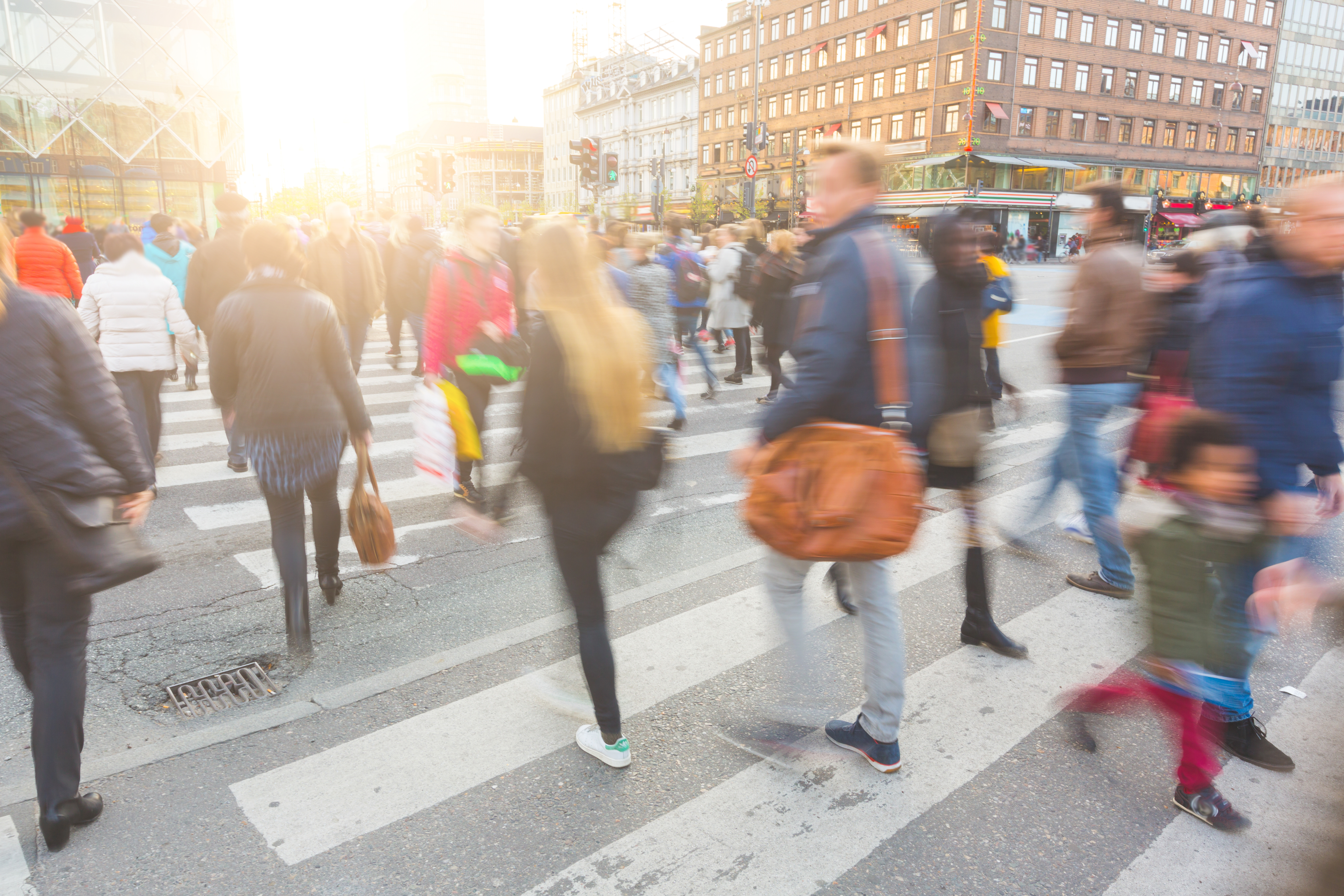 People walking down a city street, representing social drivers of health in the community.