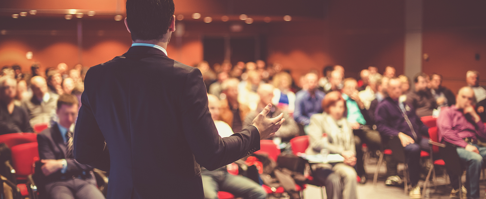 Image of a speaker presenting to an audience